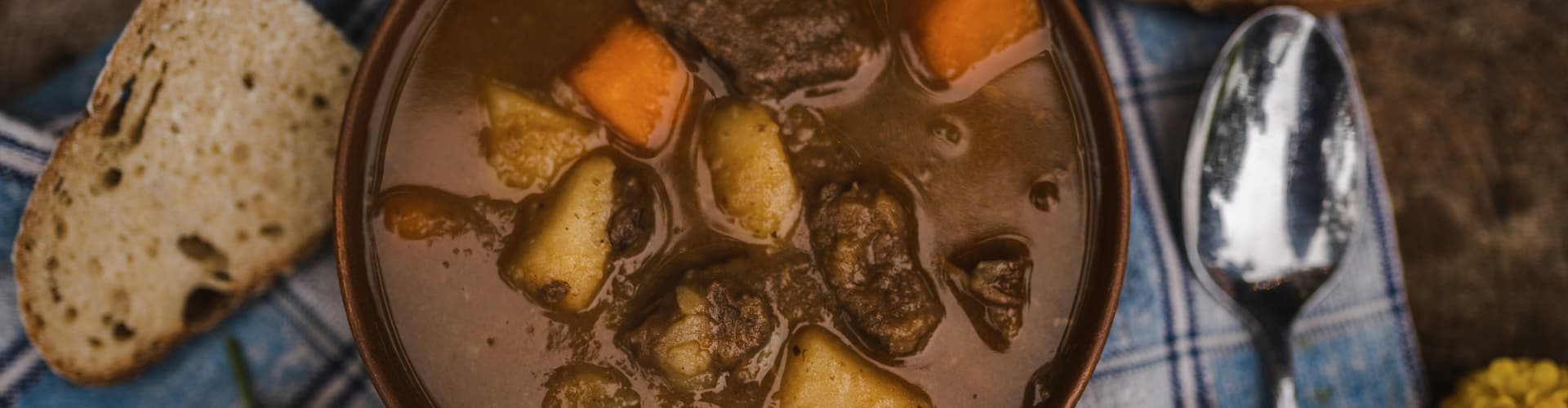 A harvest feast consisting of a hearty bowl of beef stew and a side of sourdough bread