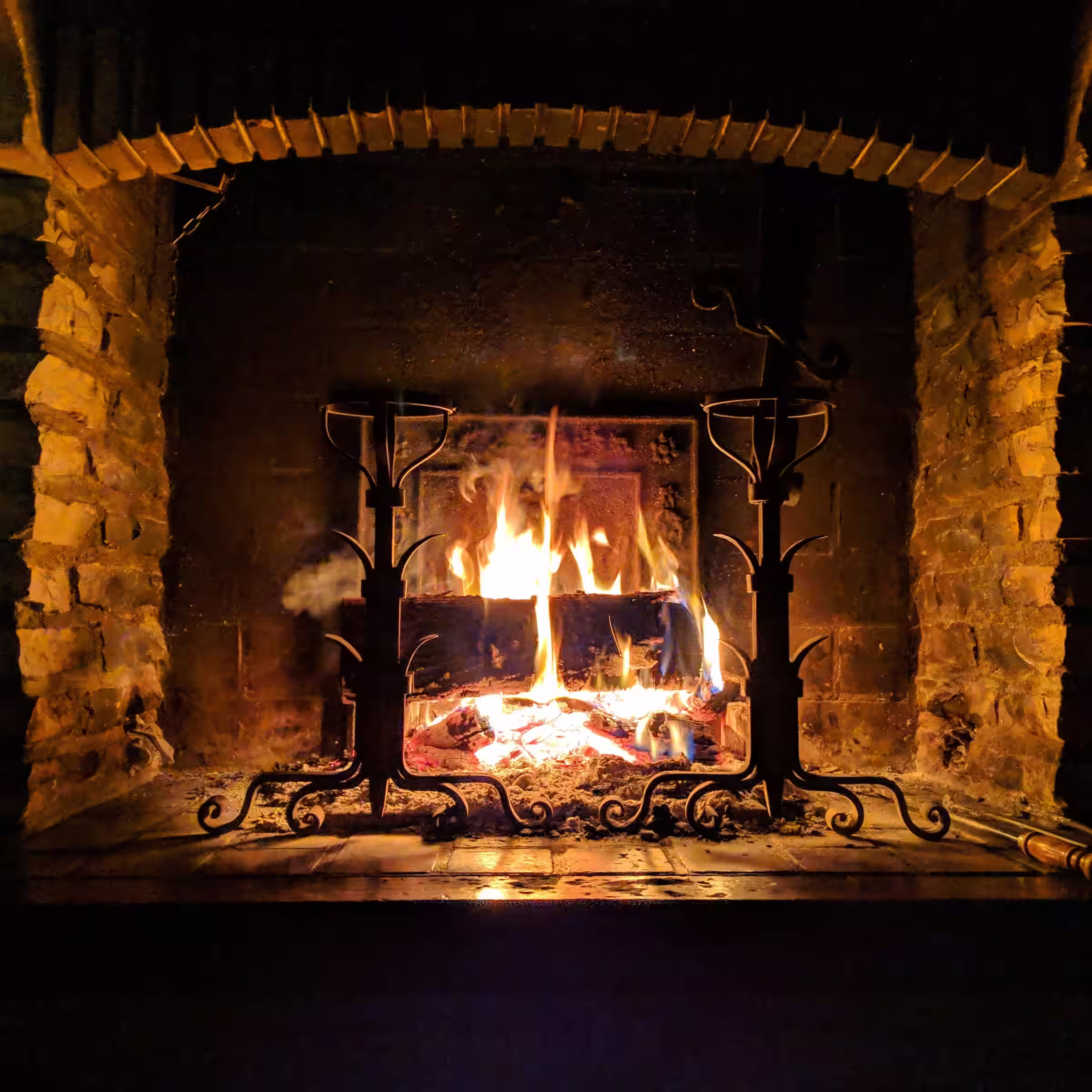 A cozy brick fireplace emitting a warm glow in an otherwise dark cabin in rural Canada