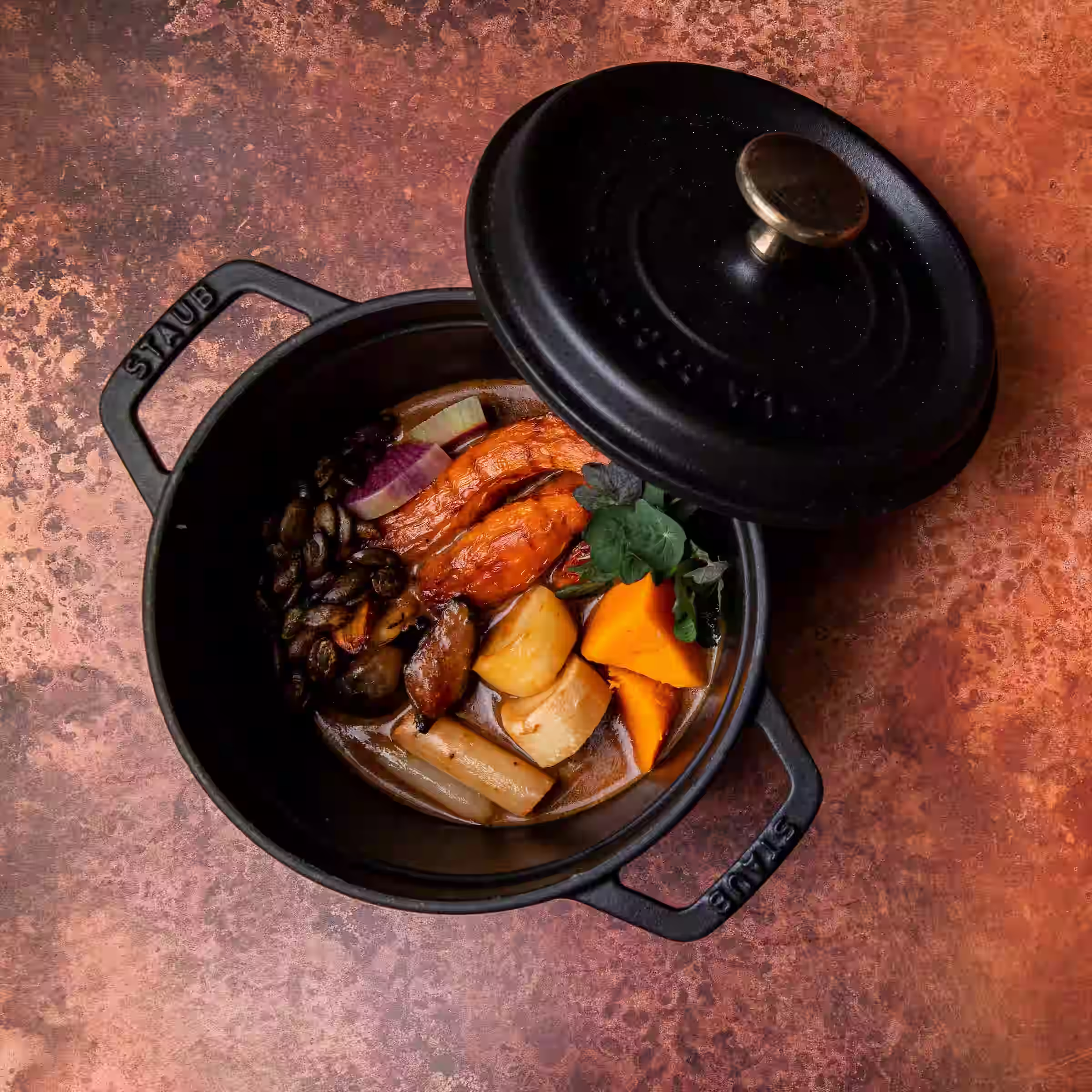 A black bot of stew with the ingredients separated nicely so you can see the carrots, potatoes, and other ingredients.